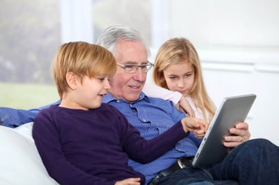 Grandfather with kids using electronic tab (1) (1)