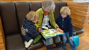 grandmother reading to twin grandchildren