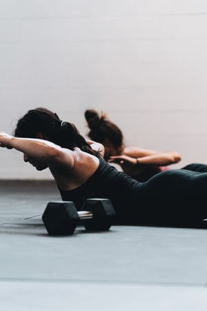 two woman practicing Pilates together indoors