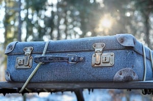 frosty luggage strapped on top of car in suitcase
