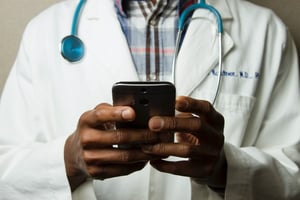 Doctor utilizing remote patient monitoring on mobile device
