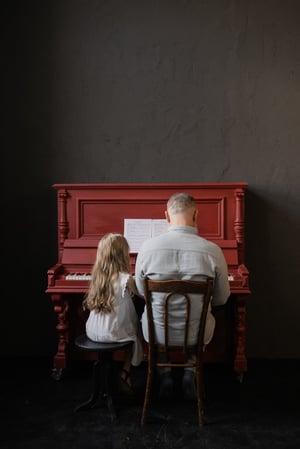 Grandfather  playing piano with granddaughter