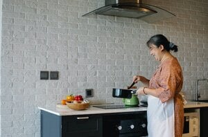 older woman cooking alone in kitchen