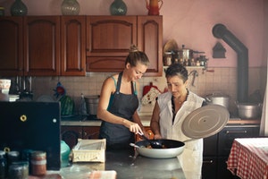 older woman cooking with daughter at home