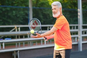 older gentleman playing tennis outdoors