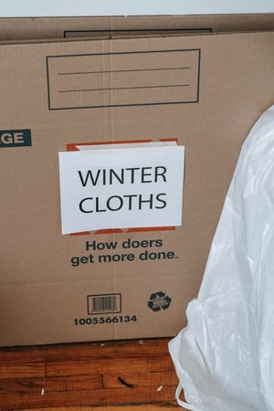 unpacking box of winter clothing 