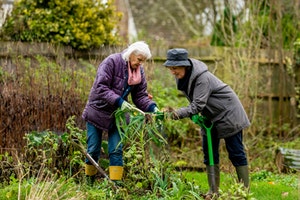 two older women working together in garden