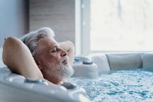 older man relaxing in bath tub