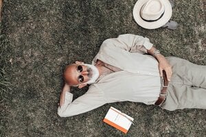 older gentleman resting outdoors with a book