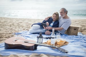 older couple laying on blanket having a picnic