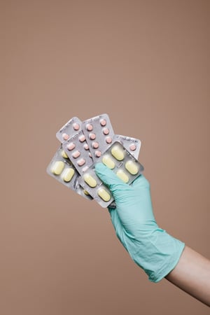 holding medications with glove to be thrown out
