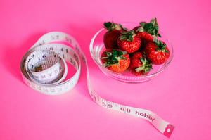 weight loss tape measure and bow of strawberries