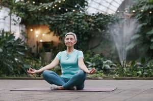 calm older woman meditation in garden