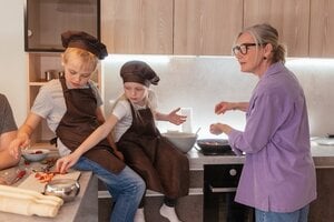 grandmother cooking in kitchen with grandchildren