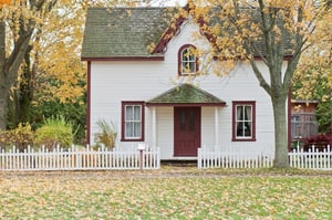 house in autumn with fallen leaves in yard