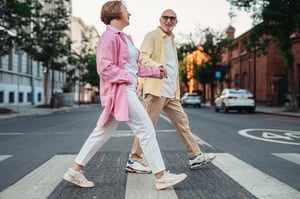 older couple walking across the street in proper footwear walking shoes