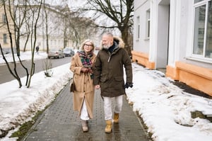 older couple walking together outdoors in the winter