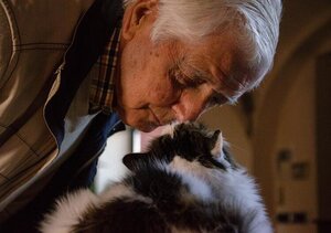 older man with pet cat