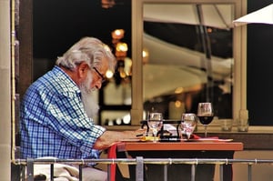 older gentleman eating at restaurant patio